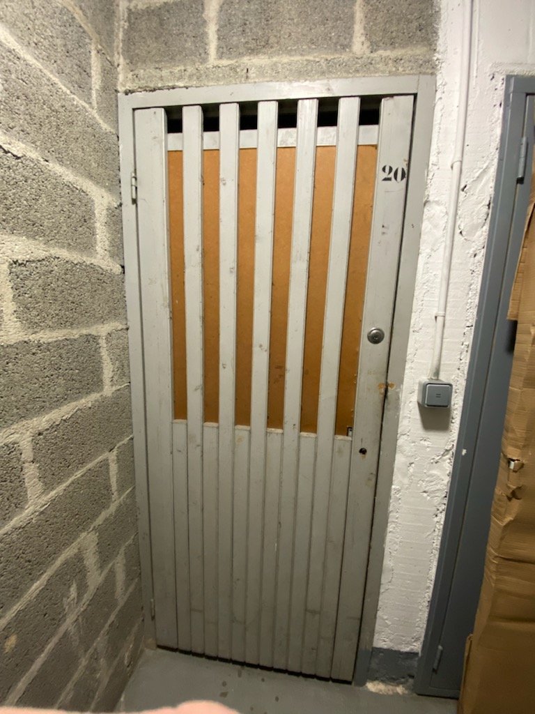 Porte de cave ajourée en bois avant intervention de France Clef