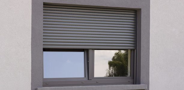 Volet roulant gris foncé fermé à mi-hauteur de la fenêtre